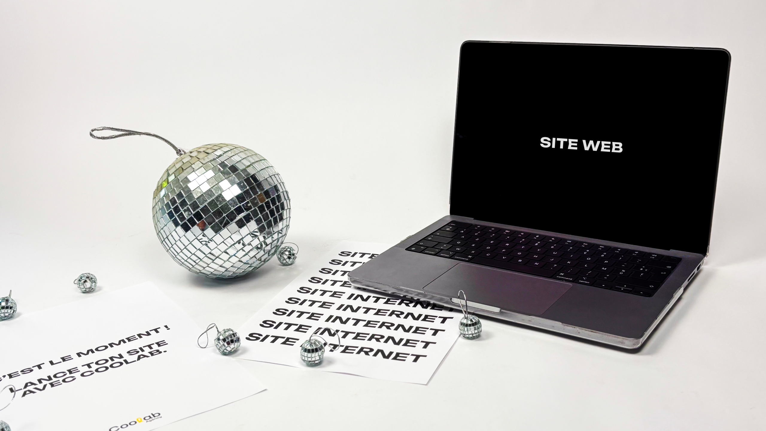 Ordinateur avec étiquette "site internet" et boule disco. Direction Artistique et Web Design à Mériel